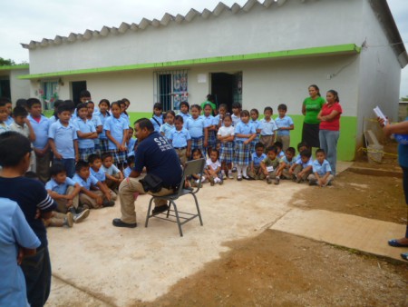 personal docente y alumnos atento a charla con el psicologo