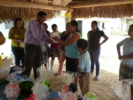MADRE RECIBIENDO EL REGALO DE MANOS DEL DIRECTOR VICTOR MANUEL.