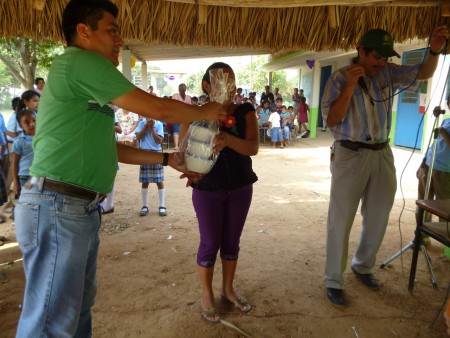 MAESTRO ALEJANDRO ENTREGANDO EL REGALO A LA MADRE AGRACIADA